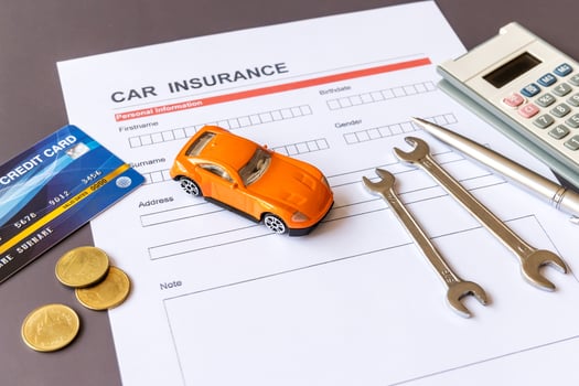 Car insurance form with model and policy document photo