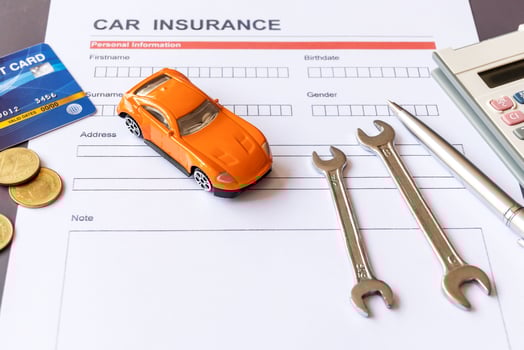 Car insurance form with model and policy document photo