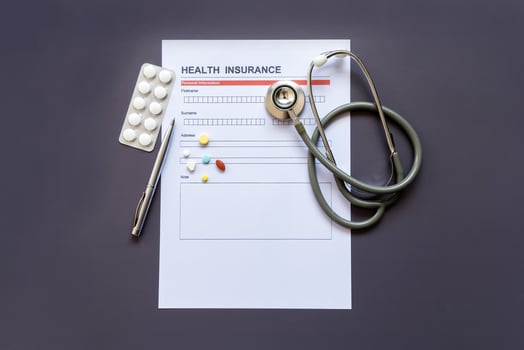 Health insurance form with model and policy document photo