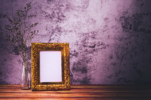 Picture frame with flowers on wall background and wooden table. Poster product design styled photo