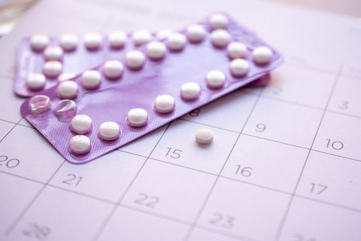 birth-control pill with date of calendar background, health care and medicine concept photo