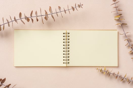 blank notebook with eucalyptus mock up on  pastel peach table photo