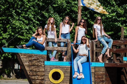 Six fabulous girl faving fun posing on a childish wooden ship in the park. photo
