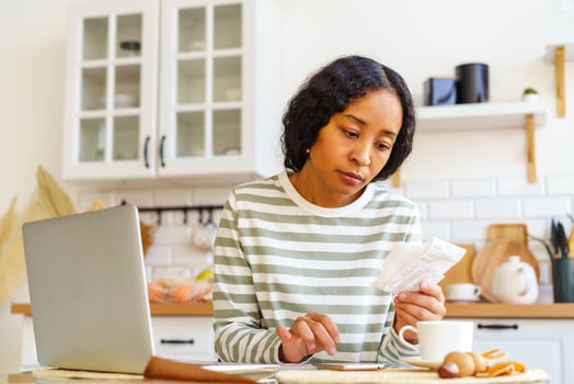 African-American female paying bills. Dealing with accountancy on smartphone. Remote bookkeeping photo