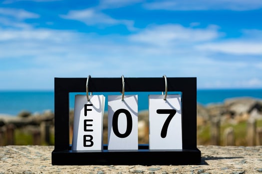 Feb 07 calendar date text on wooden frame with blurred background of ocean photo
