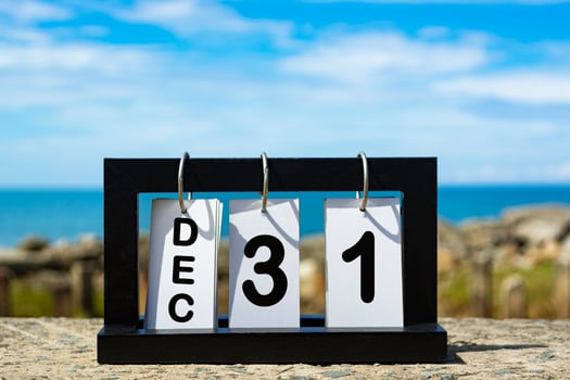 Dec 31 calendar date text on wooden frame with blurred background of ocean photo