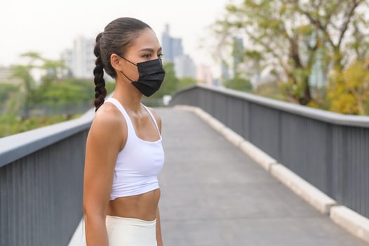 Young fitness woman in sportswear taking face mask in while exercise in city park, Health and Lifestyles. photo