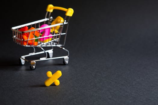 Yellow plastic sign percent on a black background with the shopping cart. Black Friday, discount percentage, shopping, buying and selling, promotion. Space for text photo