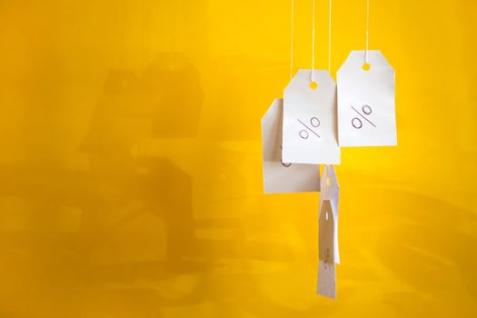 White tags with the percent sign hang on strings on a yellow background with shadows. Commerce, discount, sale, trade offer. Copy space, mock up. photo