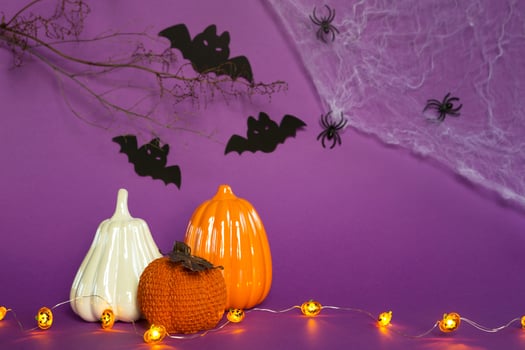Halloween backgrounds of white, orange and gold pumpkins, spiders and black bats on a purple background with cobwebs and terrible scenery. Horror and a scary holiday with copy space photo