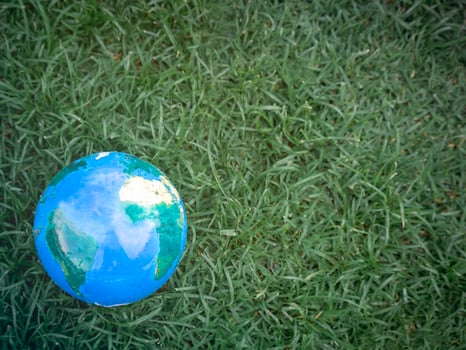 Earth on on green grass, save the world, love and protect our planet, and environmental friendly concept photo