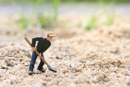 Miniature worker doll holding shovel for working, miner man at work tiny figure toy model digging ground or gardening photo