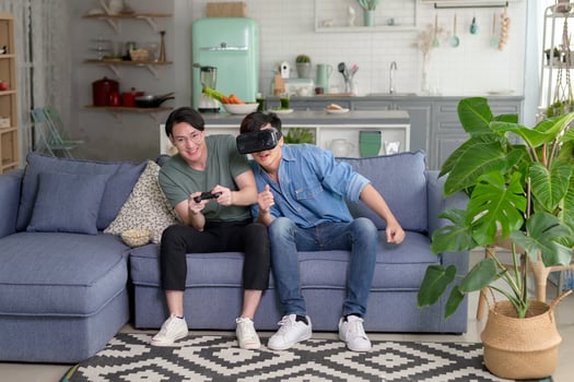 Young smiling gay couple playing video games in the living room at home, LGBTQ and diversity photo