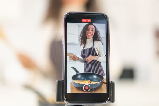 Latin woman shooting video and cooking at the kitchen photo
