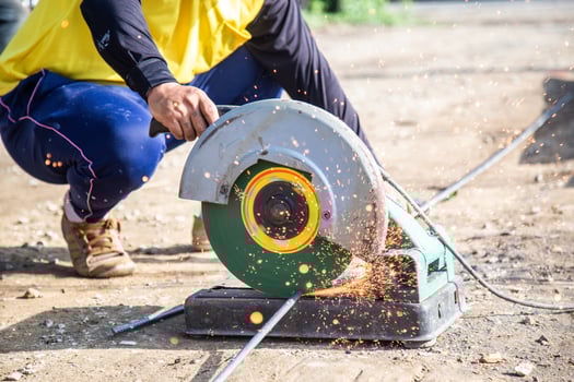 A worker cutting steel with a circular steel cutter. photo