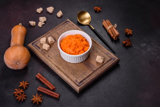 Pumpkin carrot baby puree in bowl on a dark background photo