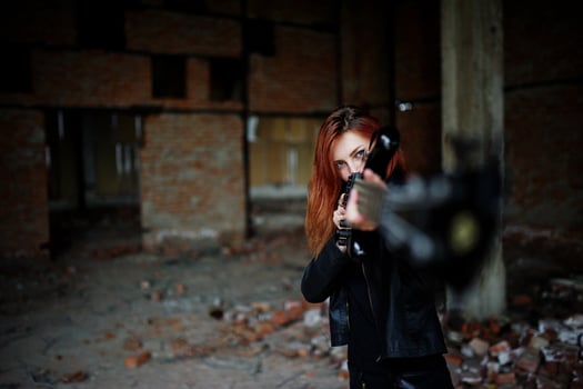 Red haired punk girl wear on black with bass guitar at abadoned place. Portrait of gothic woman musician. photo