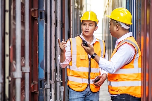 Professional of two engineer or supervisor checking and control loading Containers box from Cargo at harbor. Transportation and logistic concept photo