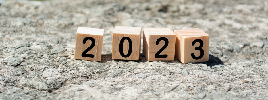 2023 number on wooden cube block on stone with blurred background of ocean photo