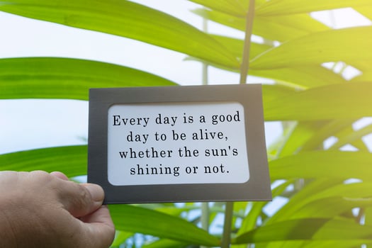 Motivational and inspirational quote on hands holding framed paper photo