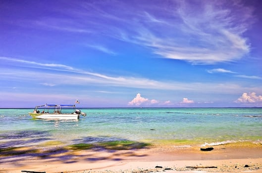 Travel destination, Malaysia. Flag of Sabah on sailing boat Mantanani Island photo