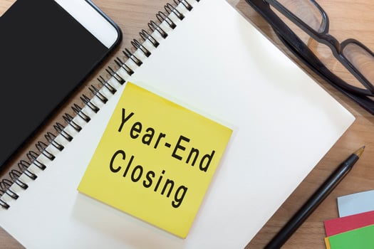 Text on yellow note with notepad on wooden desk - Year-end closing photo