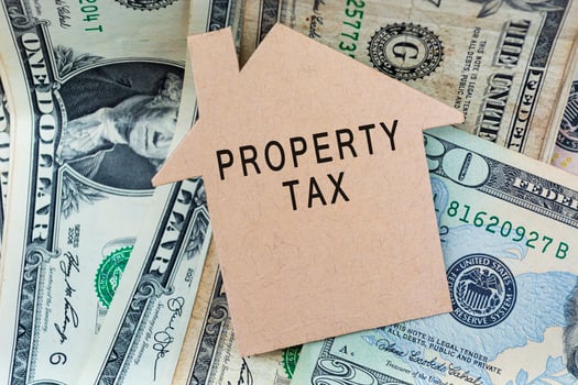 Property tax text on brown paper house model with dollar banknotes on a desk photo