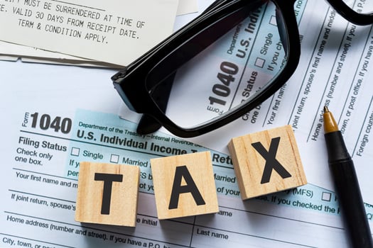 Tax on Alphabet wooden block cube with Tax forms 1040. U.S Individual Income Tax photo