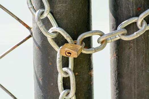 A lock and chain on Metal Fence that links of a gate. photo