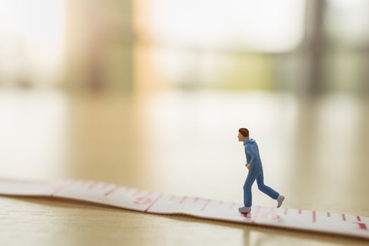 Sport and fitness concept. Close up of man runner miniature figure people running on measure tape on wooden table with copy space photo