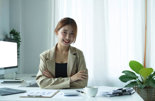 Portrait of confident young entrepreneur sitting at modern workplace and smiling to camera. photo