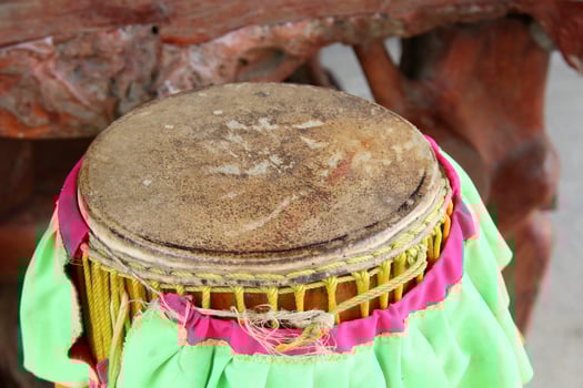 Round surface of old tall narrow drum, scratches on drum and green cloth cover beside, Thailand. photo