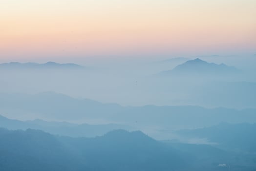 Scenery view of the mountains in the mist layer background. View from Phu Chi Fah in Chiang Rai province of Thailand. photo