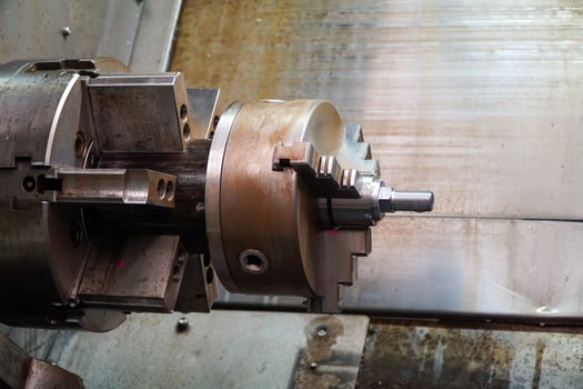 Solid steel metal workpieces mounted on spindle chucks of high-precision CNC automatic lathes photo
