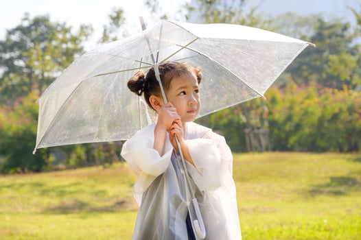 A little girl was happily standing in an umbrella against the rain photo