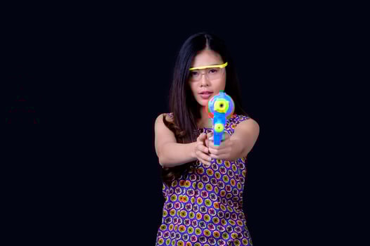 A beautiful Asian woman shows a gesture while holding a plastic water gun during the Songkran festival photo