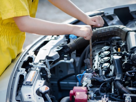 The mechanic's hand is measuring the engine oil level photo