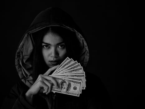 A young woman shows a lot of the money she earned from using methods to search for information photo