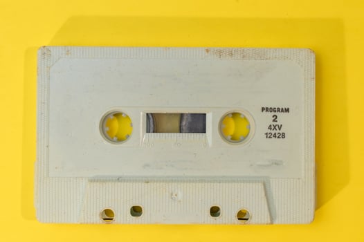 old retro cassette tape with grunge label on yellow background flat lay photo