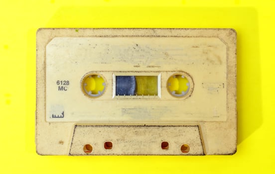 old retro cassette tape with grunge label on yellow background flat lay photo