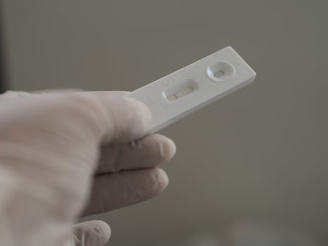 Asian woman wear rubber gloves hold ATK Antigen test kit covid-19 virus test photo