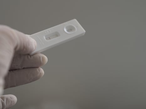Asian woman wear rubber gloves hold ATK Antigen test kit covid-19 virus test photo