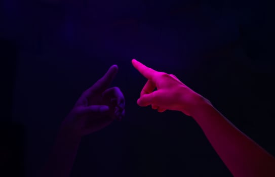 Woman pointing finger to blank screen on blue monitor in the night. photo