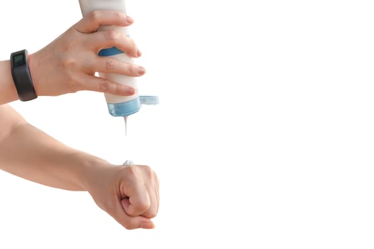 Woman pouring sun protection cream on her hand isolated in clipping path. photo