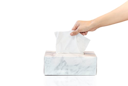 Woman hand picking white tissue paper from tissue box isolated in white background. photo