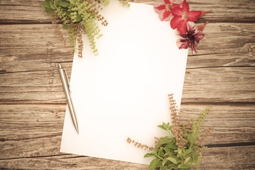 Conceptual space for text, which consists of blank paper, azalea, basil flowers,and pens on a wooden background.Blank template for your text.top view.flat lay photo