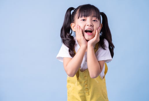 Portrait of Asian child posing on blue background photo