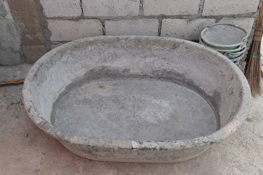 Empty cement mixing container is placed on the construction site of the house. Around there are equipment for construction work. photo