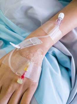The piercing needle for giving saline solution to patients on the back of the hand. photo