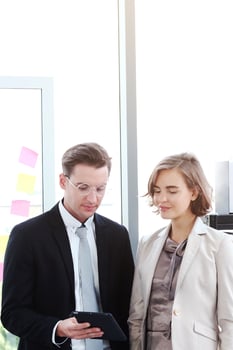 Successful businessman and businesswoman meeting and hand holding laptop for good ideas in modern office photo